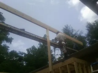 Carpenter setting a ridge beam over a new addition frame — Ice Dam Removal by Roofing Brothers in Blandon