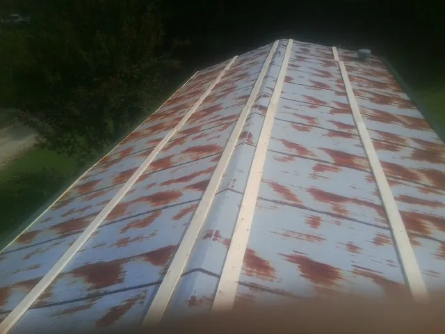 Rusted metal roof panels with new wood purlins before replacement — Storm Damage Roof Repair in Blandon by Roofing Brothers